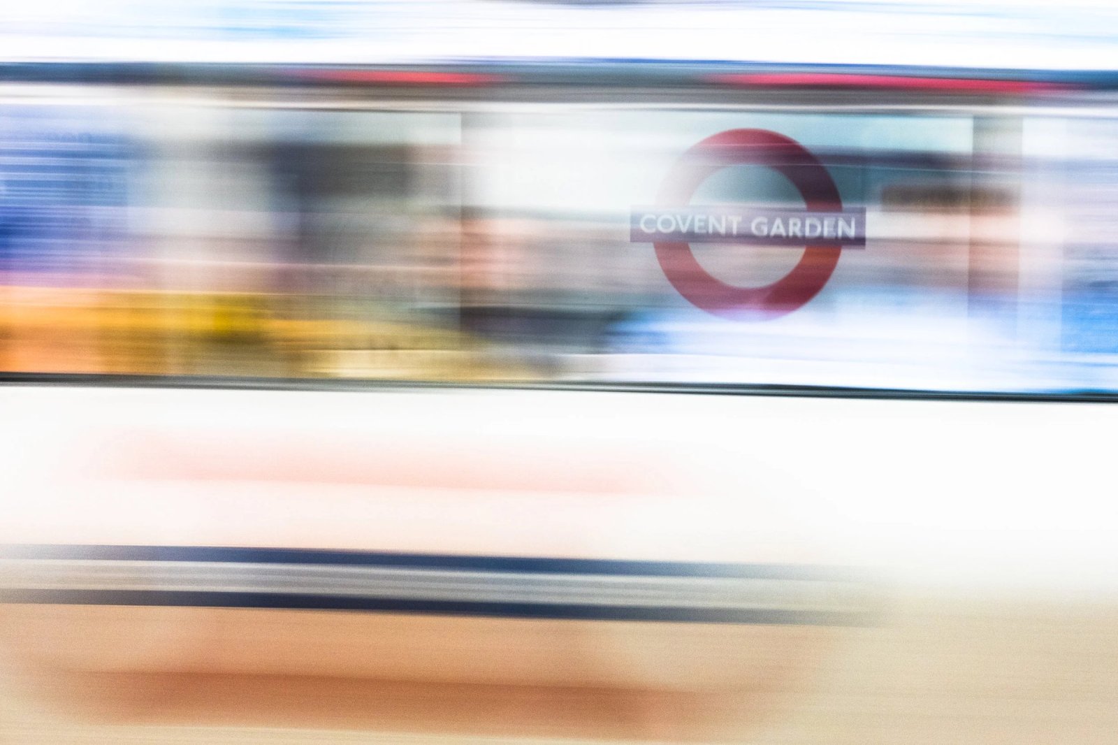 A London Underground train blurs past the Covent Garden station sign